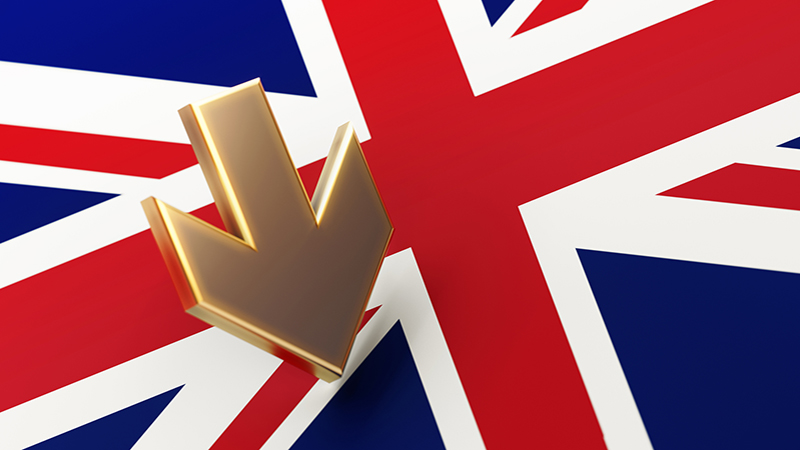 Arrow symbol standing on British flag. Selective focus. Horizontal composition with copy space.